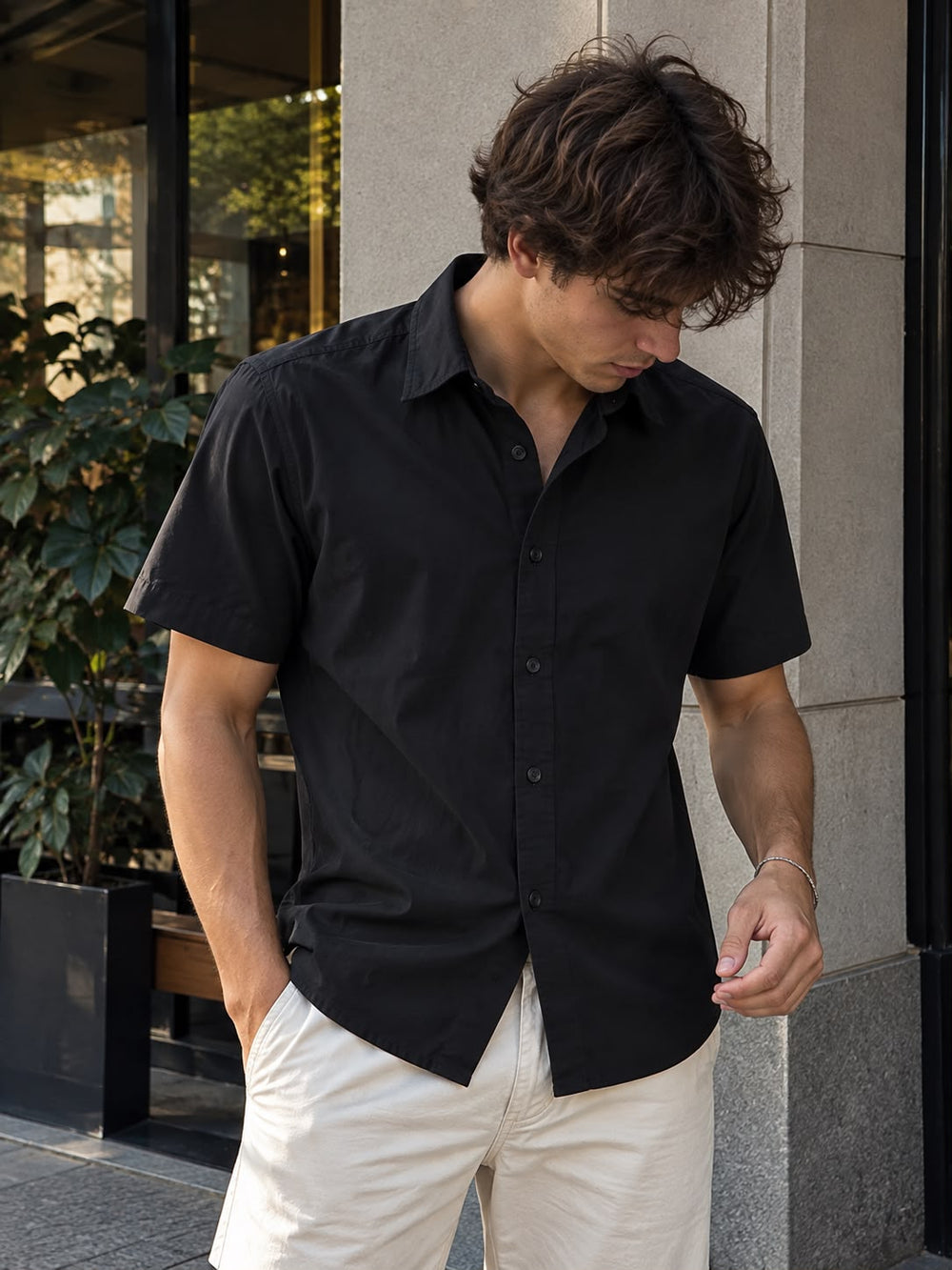 Hombre usando la camisa de lino y algodón negra con pantalón claro