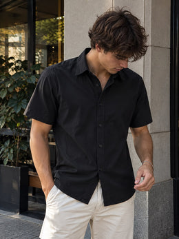Hombre usando la camisa de lino y algodón negra con pantalón claro