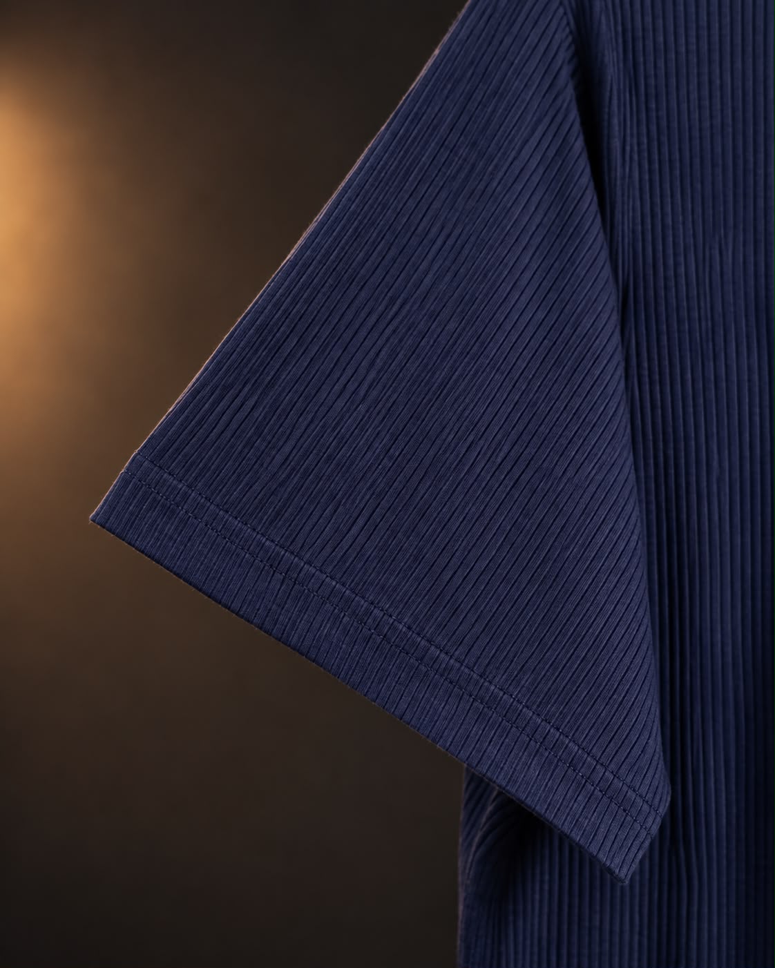 Detalle de la tela acanalada en la manga de la remera azul