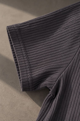 Detalle de la tela acanalada en la manga de la remera gris