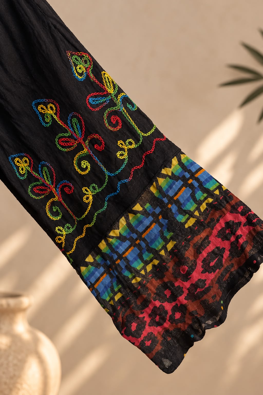 Detalle del bordado de colores en la manga del vestido negro