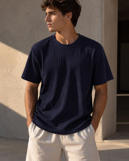 Hombre usando la remera acanalada azul con pantalón claro