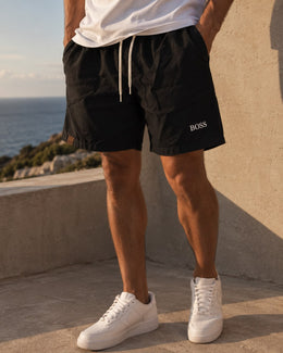 Hombre usando el short liviano negro con remera blanca y zapatillas blancas