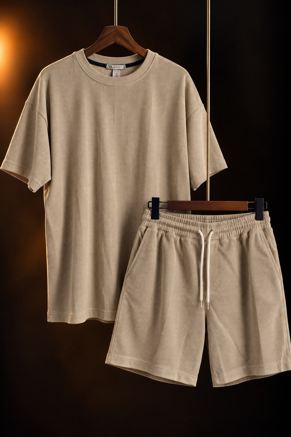 Conjunto de remera y short beige para hombre colgado en perchas