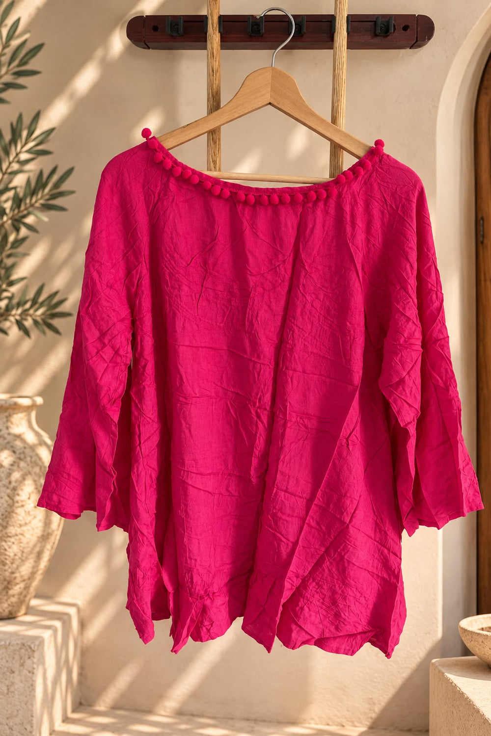 Remerón rosa de mujer, amplio y de mangas 3/4, colgado en percha