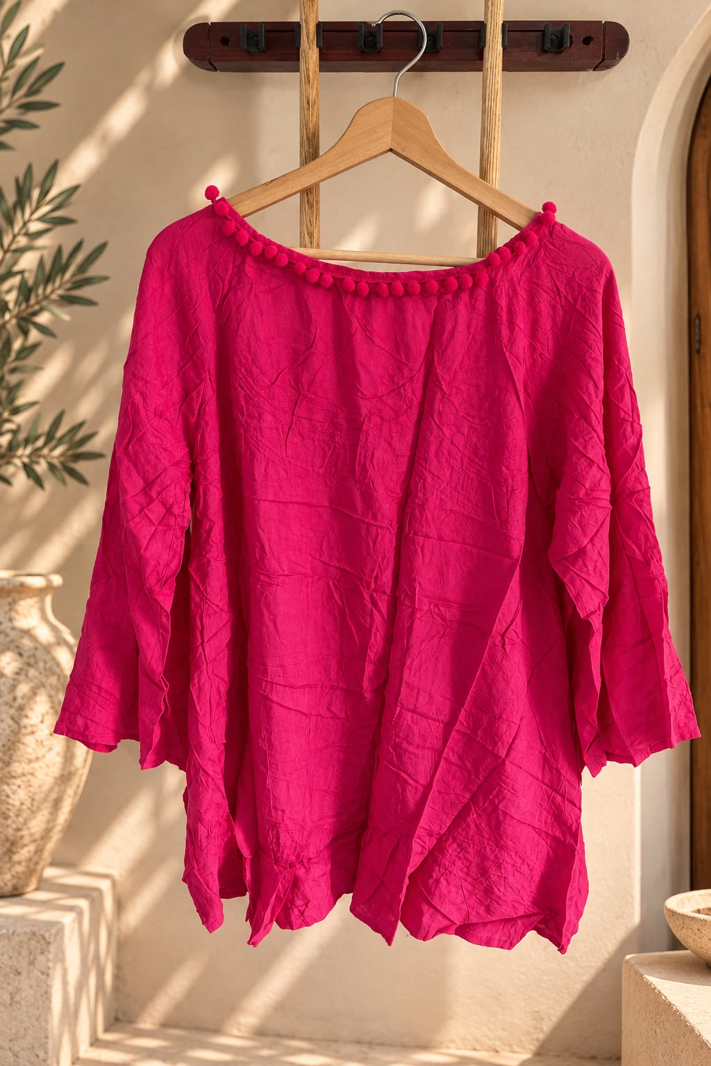 Remerón rosa de mujer, amplio y de mangas 3/4, colgado en percha