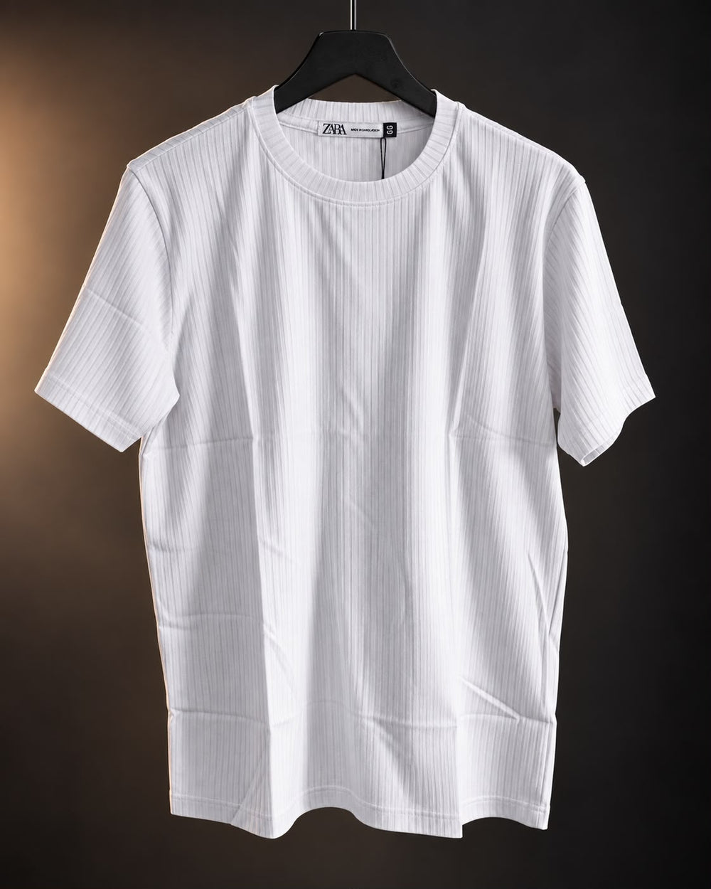 Remera acanalada blanca de hombre colgada en percha