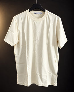 Remera básica manteca de hombre, lisa y de cuello redondo, colgada en percha