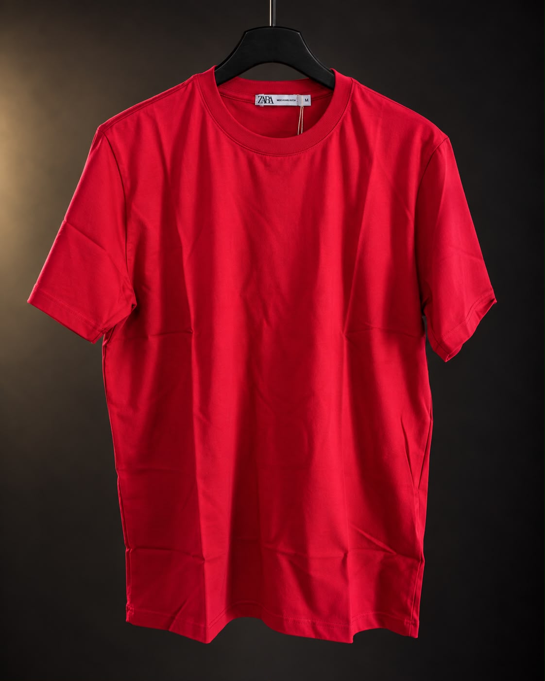 Remera básica roja de hombre, lisa y de cuello redondo, colgada en percha