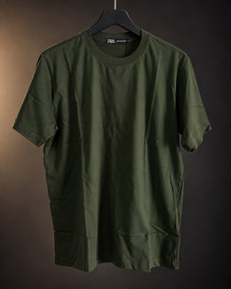 Remera básica verde de hombre, lisa y de cuello redondo, colgada en percha