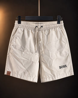 Short liviano manteca para hombre con cordón en la cintura, colgado en percha