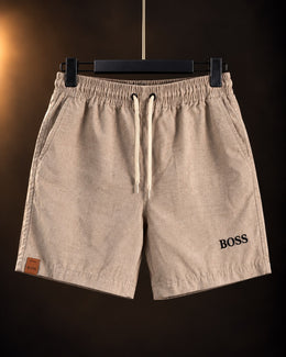 Short liviano beige para hombre con cordón en la cintura, colgado en percha