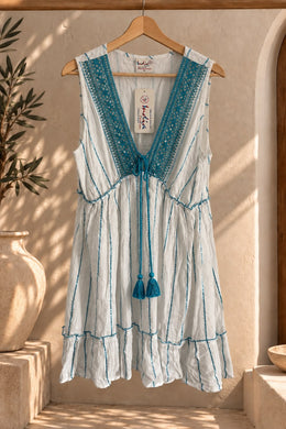 Vestido corto blanco con rayas celestes y escote en V bordado, colgado en percha